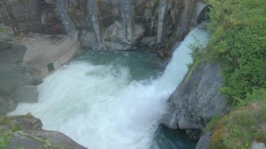 Barajın kapısından akan su manzarası. Suyun gücü. İsviçre.