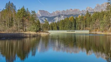 Zaman kaybı, dağlarla çevrili göl. Chapfensee Gölü, dağların tepesindeki hidroelektrik deposu. Mels, St. Gallen Kantonu, İsviçre.
