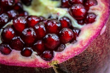 Nar tohumunu kapat. Olgun kırmızı nar tohumlarının görüldüğü açık nar meyvesi. Meyve aromalı. Makro.