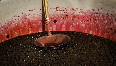 Pankart. Yaban mersini reçel için pişirilir. Boğaz reçeli pişiriyorum. Yaban mersini. Aronia. Kepçeli bir tencerede.