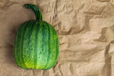 Yeşil balkabağı. Kahverengi kağıtta yeşil balkabağı. Olgun biçilmiş balkabağı. Metni kopyala.