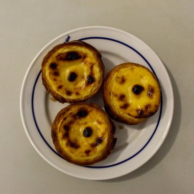 Tipik Portekiz kremalı turtaları, Pastel de Nata veya Pastel de Belem. Geleneksel kafede geleneksel Portekiz kremalı pastalarının yakın çekimi: Restoran. Pastel de nata. Pastis de Belm. 