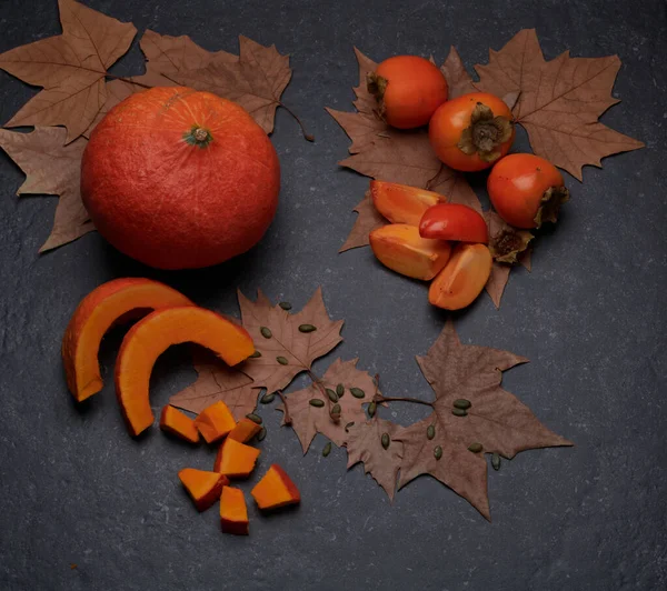 Légumes et fruits automnaux : Citrouille, kaki, tranchés, entiers, frais et crus — Photo