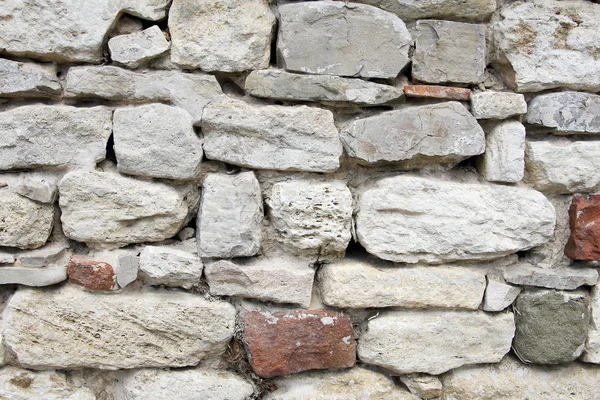 Massive Steinmauer, die die Grundlage für die antike Mauer bildet — Stockfoto