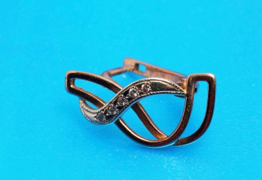 bir altın küpe mavi arka plan üzerinde kapat