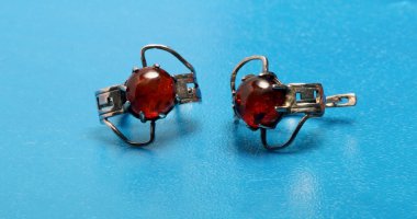 mavi bir arka plan üzerinde kahverengi taşlarla ilginç küpe