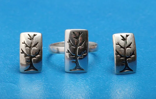 Conjunto de jóias de prata fez a árvore no fundo azul — Fotografia de Stock