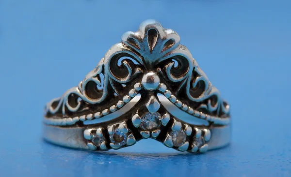 Silver ring with a crown on blue — Stock Photo, Image