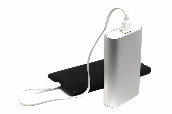 Teléfono móvil polvoriento y una batería externa sobre un fondo blanco — Foto de Stock