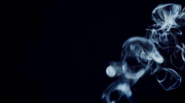 Sağlıksız bir yaşam tarzı. sigara dumanı bulutları sanatsal soyut desenleri çeker. koyu arkaplan