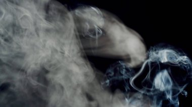 Sağlıksız bir yaşam tarzı. sigara dumanı bulutları sanatsal soyut desenleri çeker. koyu arkaplan