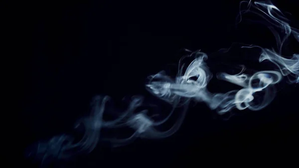 unhealthy lifestyle . cigarette smoke clouds draws artistic abstract patterns. dark background