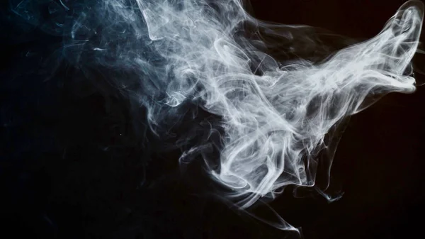 unhealthy lifestyle . cigarette smoke clouds draws artistic abstract patterns. dark background