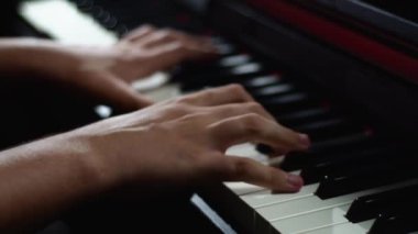 Stüdyoda piyano klavyesi çalan müzisyen. Yakın çekim