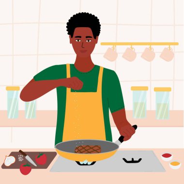 Afrikalı zenci adam mutfağında yemek pişiriyor. Kırmızı gömlekli ve yeşil önlüklü bir erkek kızartma tavasında biftek pişiriyor. Eldeki tuz. Çizgi film vektör illüstrasyonu