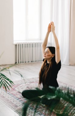 Güzel esmer kadın meditasyon yapıyor, evde yoga yapıyor. Formda ve sağlıklı kalmak. Yüksek kalite fotoğraf