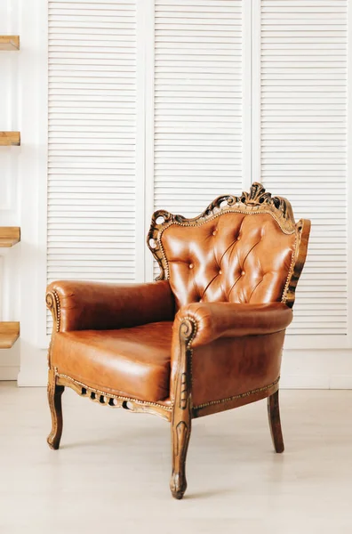 Stylish leather brown armchair in white living room. High quality photo