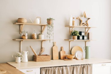 Provence tarzında parlak bir mutfak. Ev bitkileri, ahşap tabaklar, mutfak aksesuarları ve raflar..