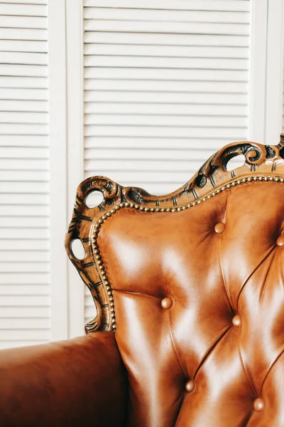 Stylish leather brown armchair in white living room. Close-up. High quality photo