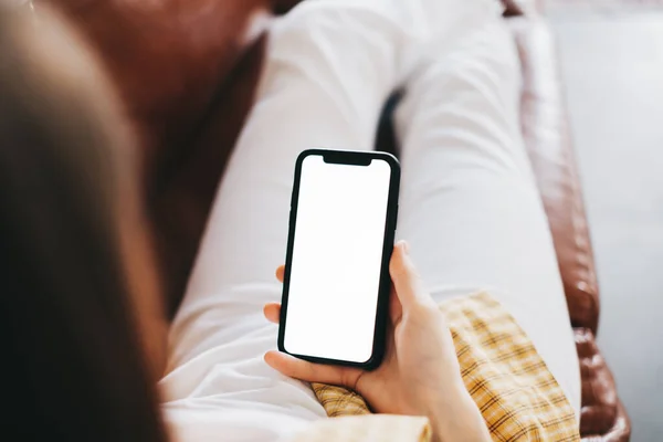 Mulher Segurando Smartphone Com Uma Tela Branca Zombar Enquanto Sentado — Fotografia de Stock