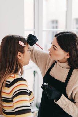 Kaş şekillendirme prosedürü, makyaj ustası kaşları şekillendirmek için fırça kullanır. Yüksek kalite fotoğraf