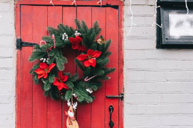 Noel çelengiyle süslenmiş kırmızı ahşap kapı. Yüksek kalite fotoğraf