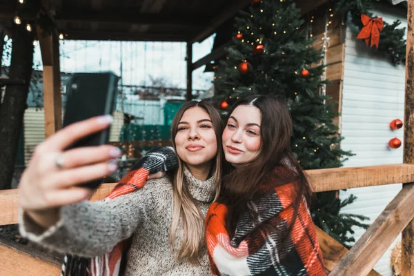 两个快乐的高加索女人朋友玩得很开心 在后院用圣诞装饰品做自拍 — 图库照片