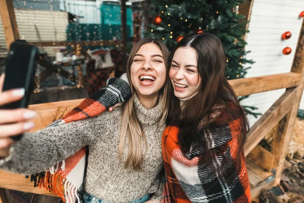 两个快乐的高加索女人朋友玩得很开心 在后院用圣诞装饰品做自拍 — 图库照片