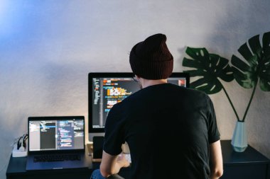Genç adam mobil geliştirici bir bilgisayara program kodu yazar, programcı da merkez ofiste çalışır. Yüksek kalite fotoğraf