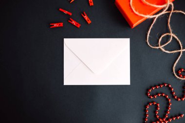 Siyah arka planda hediye kutusu olan beyaz kağıt bir zarf. Sevgililer Günü konsepti