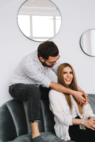 一对快乐的夫妇坐在靠近白墙的沙发上的画像 高质量的照片 — 图库照片