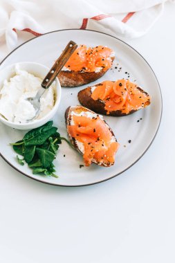 Beyaz bir tabakta somon ve peynir kremalı lezzetli tost..