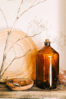 Rafta dallarla süslenmiş eski bir şişe ve ahşap tabaklar. Ev dekorasyonu