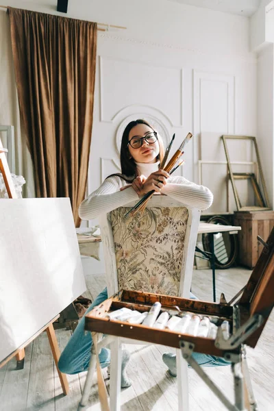 Retrato Bela Mulher Sorridente Artista Sentado Uma Cadeira Segurando Pincéis — Fotografia de Stock