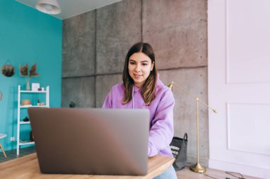 Dizüstü bilgisayarla çalışan genç bir kız öğrenci, uzaktan sınav için hazırlanıyor, ödevini evde yapıyor, uzaktan eğitim kavramı geliştiriyor..