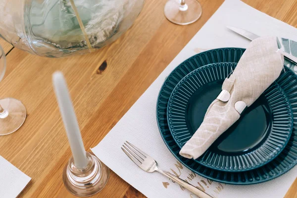 Boş tabaklar, çatal bıçak takımı ve kumaş peçeteyle servis edilen şenlik masası..