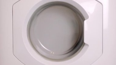 Çamaşır makinesi farklı giysileri ve çarşafları yıkar. Silindir dönüyor. Kimse.