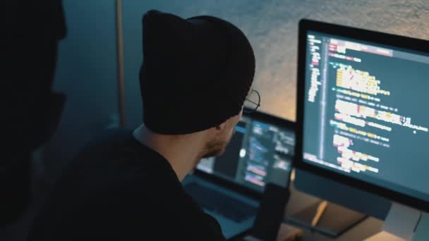 Fiatal férfi mobil fejlesztő írja programkódot egy számítógépre, programozó munka otthon iroda. — Stock videók