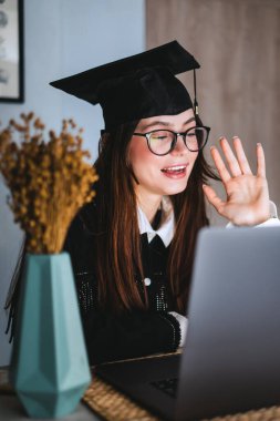 Mutlu beyaz kadın üniversite mezuniyetini arkadaşlarıyla ya da aileleriyle video görüşmesinde kutluyor..