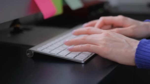 Jeune femme travaillant sur ordinateur de bureau, tapant du texte sur le clavier, gros plan. — Video