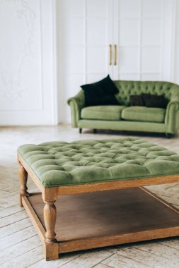 Parlak oturma odasında minimalist iç mekanı olan yeşil rahat bir kanepe..