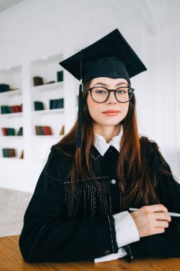 Kütüphanedeki kendine güvenen beyaz kadın öğrencinin portresi üniversite mezuniyetini kutluyor.