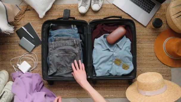 Mann packt Koffer für Reise-Urlaub in neuer Normalität von oben. — Stockvideo