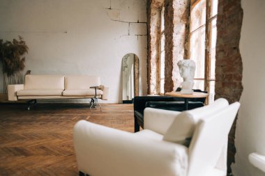 Eski moda iç mekan büyük ahşap pencere ve ayna, eski moda oturma odasında tuğla duvarlı beyaz kanepe..