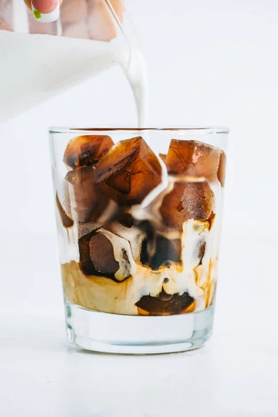 Ice Frozen Coffee Ice Cubes White Table Hand Pours Milk — Stock Photo, Image