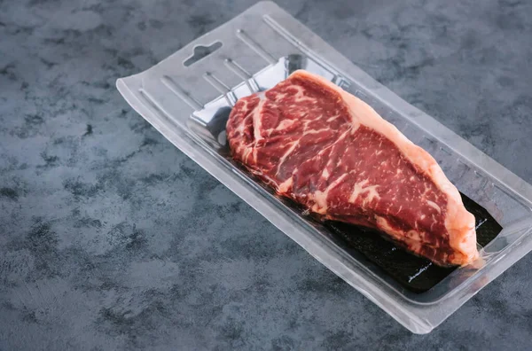 Vakuumverpackt Raw New York Striploin Beef Steak Auf Blauem Hintergrund — Stockfoto
