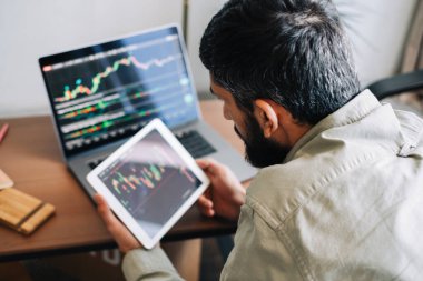 Kafkas işadamı çevrimiçi ticaret yapıyor, bilgisayar teknolojisi kullanıyor, borsa ticaretine bakıyor ve analiz ediyor.