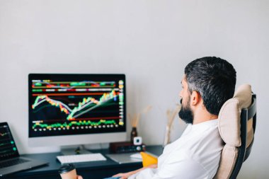 Kafkas işadamı çevrimiçi ticaret yapıyor, bilgisayar teknolojisi kullanıyor, borsa ticaretine bakıyor ve analiz ediyor.