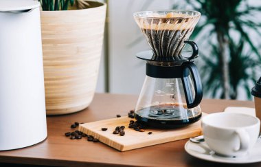 Alternatif kahve demleme metodu, damlatıcı ve kağıt filtresinin üzerine dökülüyor..