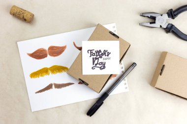 Babalar Günü 'nde babanıza bir hediye. Tatilde onu tebrik etmek için. Bej bir masada, fotoğraf üst görünümü üzerinde şölen öğeleri